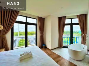 富国HANZ Sofia Hotel Grand World的一间带浴缸和大窗户的卧室