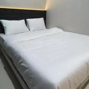 SibengkokZio Zildan Homestay的一张白色大床,配有白色床单和枕头