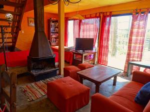 德尔迪阿布罗角Casa Amarilla con Jacuzzi的客厅设有壁炉和红色家具。