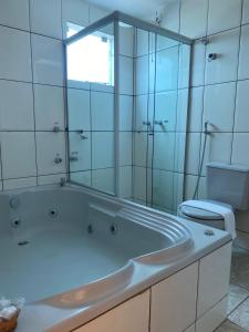 Gama锡罗斯酒店 的白色的浴室设有浴缸和卫生间。