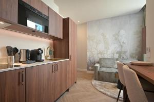 海牙Novallure Downtown - Short Stay Apartments的厨房配有木制橱柜和餐桌