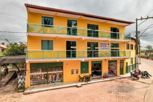 UnaPOUSADA DA ILHA的一座橙色的建筑,设有绿色的门窗