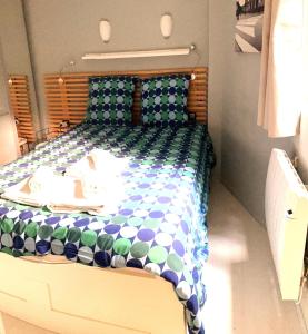 里尔Escalille le Royale的一间卧室配有一张带蓝色和绿色棉被的床