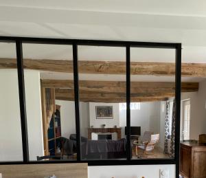 AvremesnilGite de Beaufournier的一间拥有黑色玻璃和木材的客厅