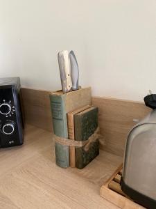 AvremesnilGite de Beaufournier的几本书,坐在架子上,拿着一把刀