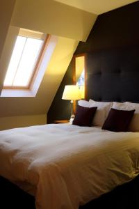 利兹尚波斯酒店的卧室配有一张白色大床和两个窗户