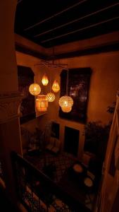 马拉喀什答图斯卡酒店的客厅设有吊灯,天花板上挂有吊灯