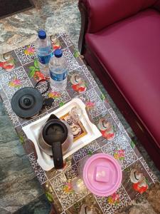 蓬蒂切里Guru Residency Pondicherry的一张桌子,上面摆放着水瓶和盘子