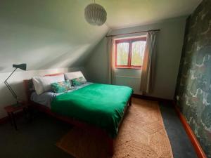 迪斯Rivendell的一间卧室设有一张带窗户的绿色床