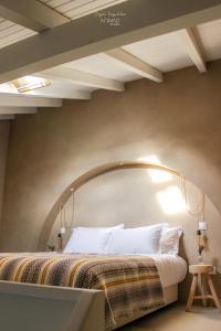 贝雅Nomad Houses - Casa Sarilho的一间卧室配有一张大床,上面有拱门
