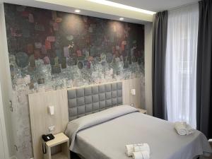 那不勒斯斯可丽齐酒店的一间卧室设有两张床和马赛克墙