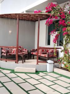 塔伊夫فلل الكناري الراقية的一座庭院,里面设有长椅和粉红色的鲜花