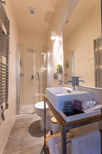 维斯圣乔治酒店的一间带水槽、卫生间和淋浴的浴室