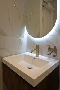 海牙Novallure Downtown - Short Stay Apartments的一间带水槽和镜子的浴室