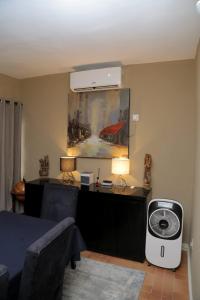 贝宁城AJ HOMES的客房设有带风扇和床的卧室。
