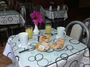 布宜诺斯艾利斯科罗尼尔酒店的一张带早餐食品和饮料的白色桌子