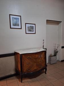 门多萨La posada del Colibrí的墙上有两张照片的房间的木梳妆台