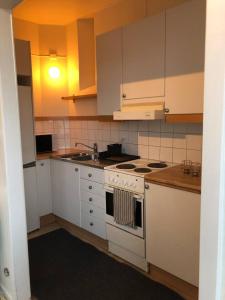 斯德哥尔摩Cozy Ostermalm Studio的厨房配有白色橱柜和炉灶烤箱。