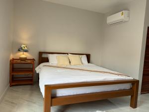 Sekaบ้านกานดา的一间卧室配有一张床和一个带灯的床头柜