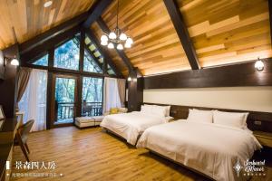 鱼池乡日月潭森堡萊夫莊園的客房设有两张床铺、木制天花板和窗户。