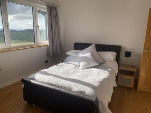 阿洛厄Immaculate 2 Bed property in rural location的一间卧室配有一张带白色床单的床和一扇窗户。