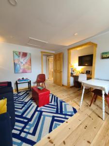 罗登La Petite Auberge Sur Queen的客厅配有白色桌子和蓝色地毯。