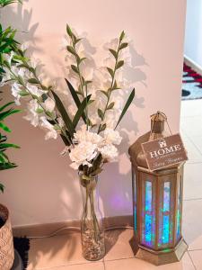 迪拜The Female Journey Hostel - JBR的花瓶,桌子旁边放着蜡烛