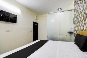 加济阿巴德OYO Flagship Hotel Blue Diamond的一间卧室设有一张床和一个滑动玻璃门