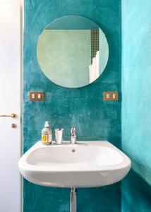 米兰Dream Suite的蓝色浴室内的白色水槽和镜子