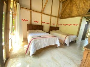 库埃察兰德尔普罗格雷索Cabañas Tosepan Kali的一间客房内配有两张床的房间