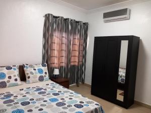 阿克拉RESIDENCE IVOIRE的一间卧室配有一张床、梳妆台和镜子