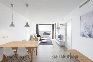 卡德斯伊斯拉克Santa Romana Apartments & Suites的白色的客厅配有木桌和椅子