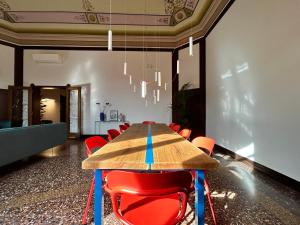 博洛尼亚Frame Bologna的一间会议室,配有木桌和红色椅子