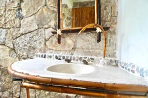 库埃察兰德尔普罗格雷索Cabañas Tosepan Kali的石质浴室设有水槽和镜子