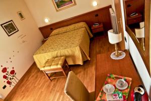 奥维多皮齐欧酒店的小房间设有一张床和一张桌子