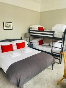 柯库布里The Garret Hotel的一间卧室配有两张双层床和红色枕头