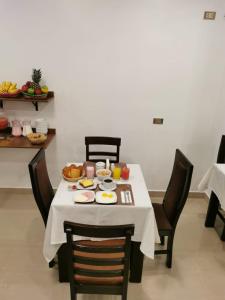 马丘比丘Mapi Gardens Machupicchu B&B的一张桌子,上面有白色的桌布和食物