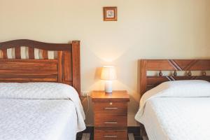 TorotoroHostal Claure的一间卧室配有两张床和床头灯。