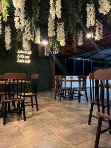 TorotoroHostal Claure的用餐区设有桌椅和白色的鲜花