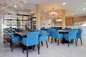 锡耶纳Siena Hills Apartments的一间设有蓝色椅子的餐厅和一间用餐室