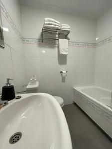 圣多明各德拉Pensión La Encina的白色的浴室设有浴缸和卫生间。