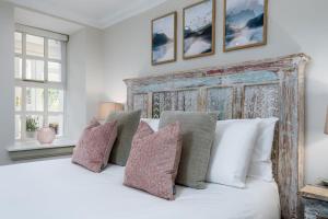 奥赫特拉德The Tranquil Auchterarder 3-bed Cottage的卧室配有带枕头的大型白色床