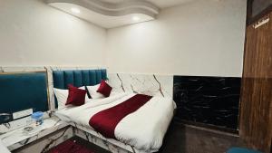 新德里Hotel Vin Inn, Paharganj, New Delhi的一间卧室配有一张带红色枕头的大床