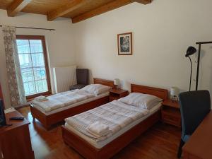 利托米什尔波扎西利托米什尔旅馆的一间卧室设有两张床、一张桌子和一个窗口。