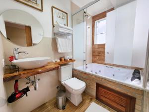 坎波斯杜若尔当Pousada Geada de Campos的浴室配有盥洗盆、卫生间和浴缸。