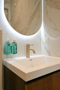 海牙Novallure Downtown - Short Stay Apartments的一间带水槽和镜子的浴室