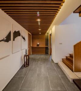 池州九华山德懋堂酒店的走廊上设有楼梯,墙上挂有绘画作品