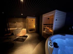 摩拉瓦托普利采Aparthotel Vital - Vital Resort的带浴缸、椅子和床的浴室