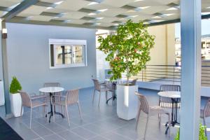 比雷埃夫斯Piraeus Relax的配有桌椅和盆栽树的房间