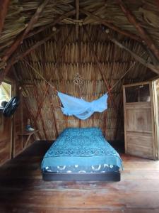 圣贝尔纳多德尔比恩托SakaNibue的茅草房内的一张床位,配有蚊帐